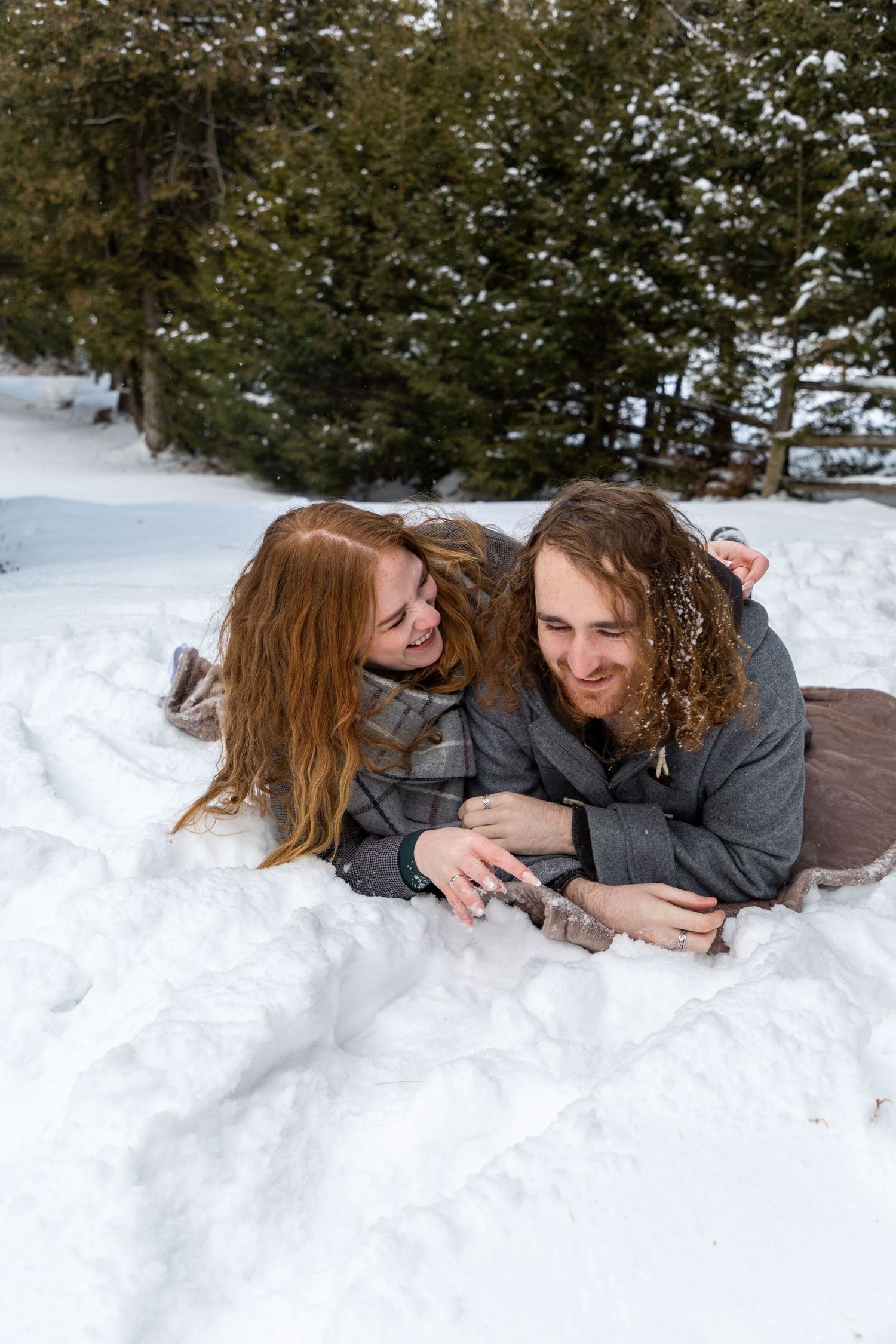 A couple rolling over each other in the snow