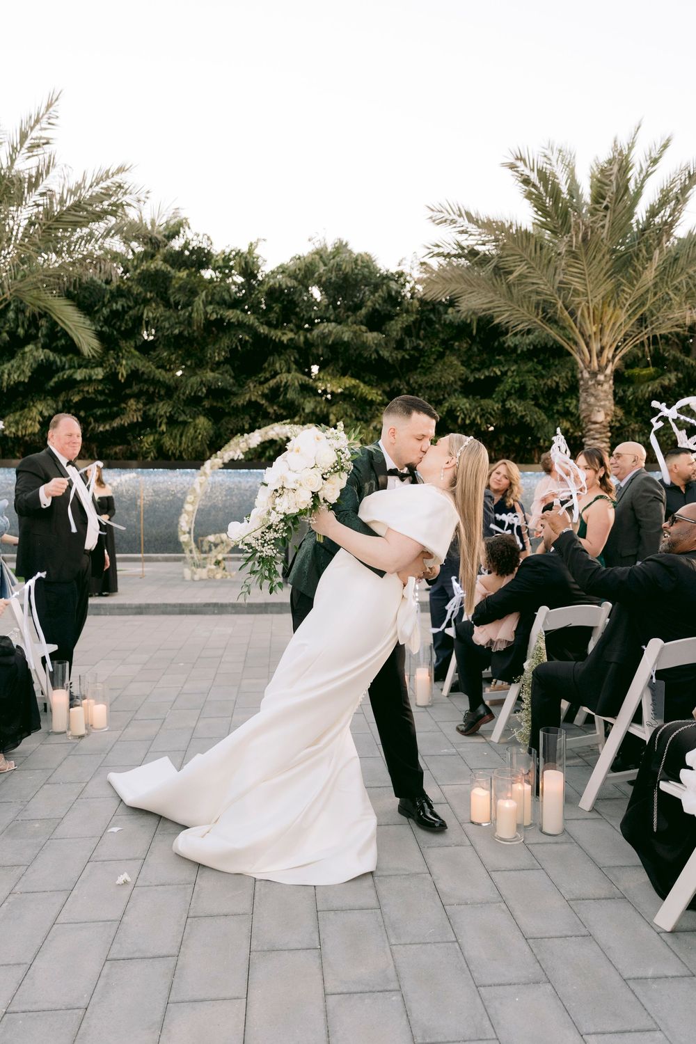 A celebratory dance moment captured at an outdoor wedding reception with guests looking on.