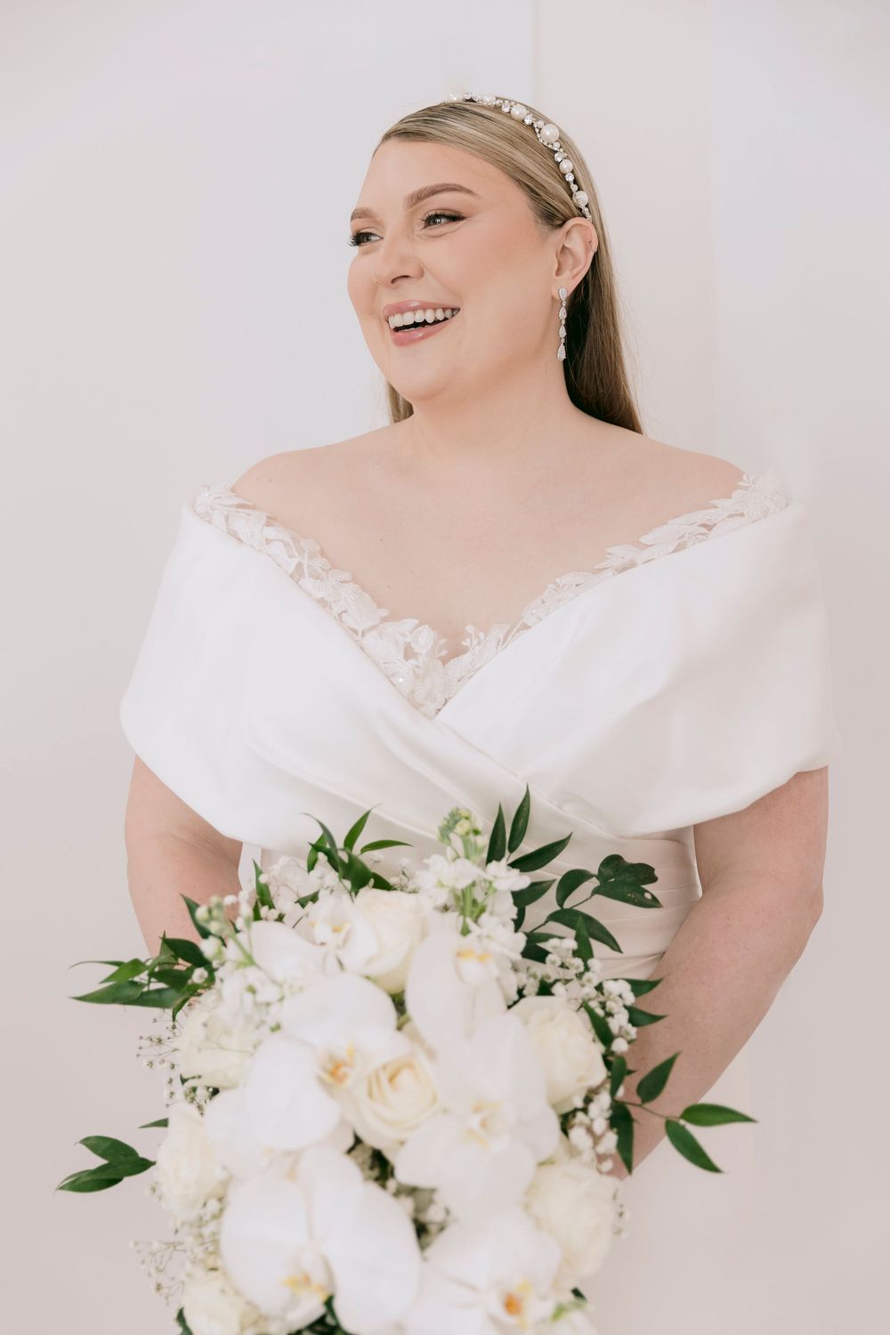 A stunning bridal portrait featuring a white bouquet with elegant greenery.