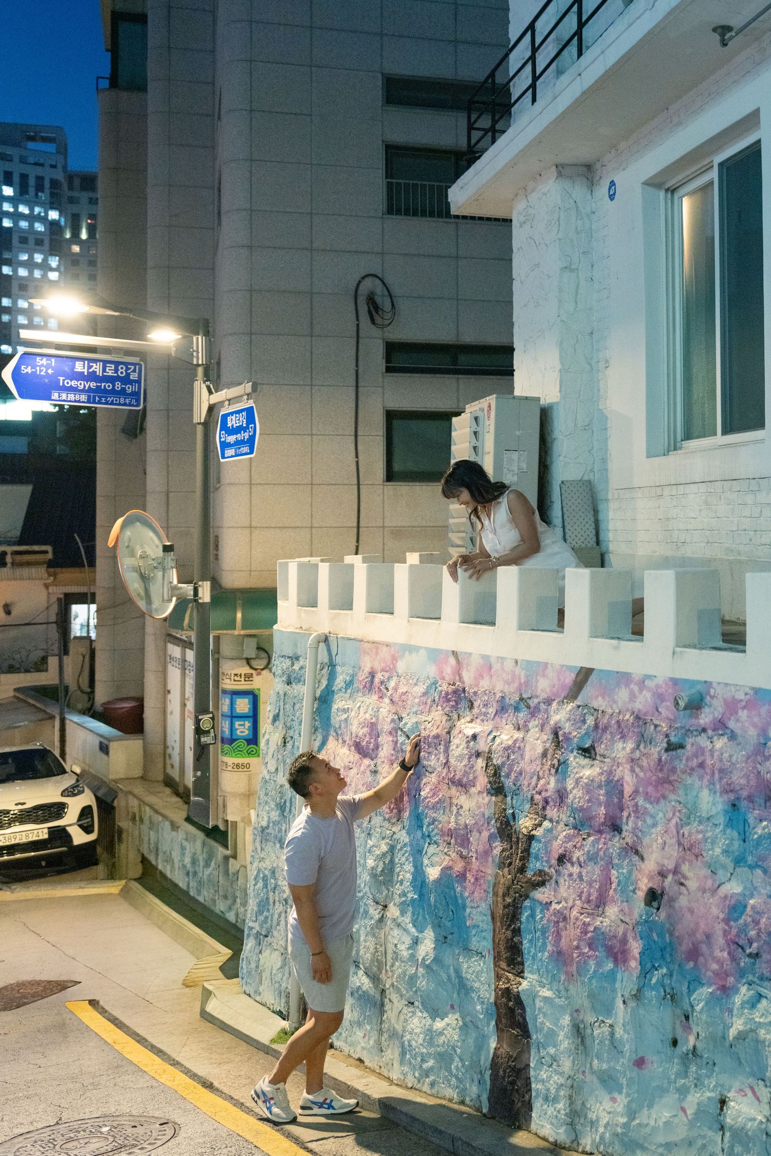 A series of photos showing someone posing and dancing against a colorful graffiti wall in an urban alleyway at night.