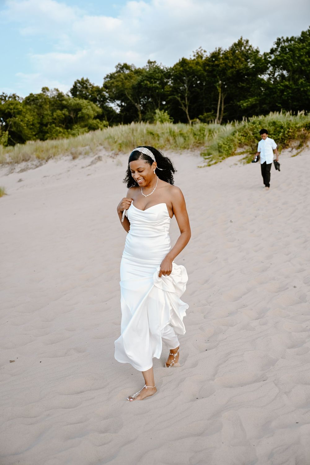 A sequence of photos shows someone in a flowing white dress walking gracefully across sandy beach dunes on a summer day.