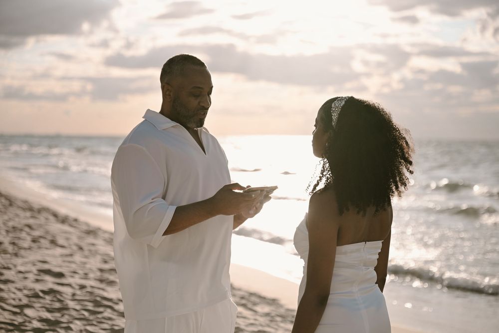A couple enjoys a romantic moment together while walking along a scenic beach at sunset.