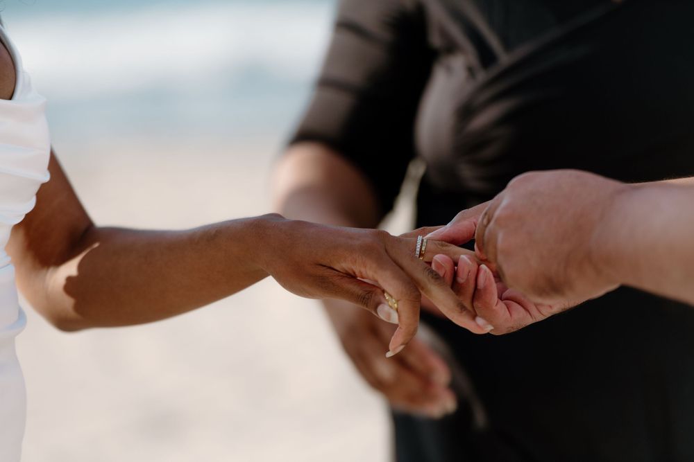 Two hands passing a white credit card between them in a payment transaction.