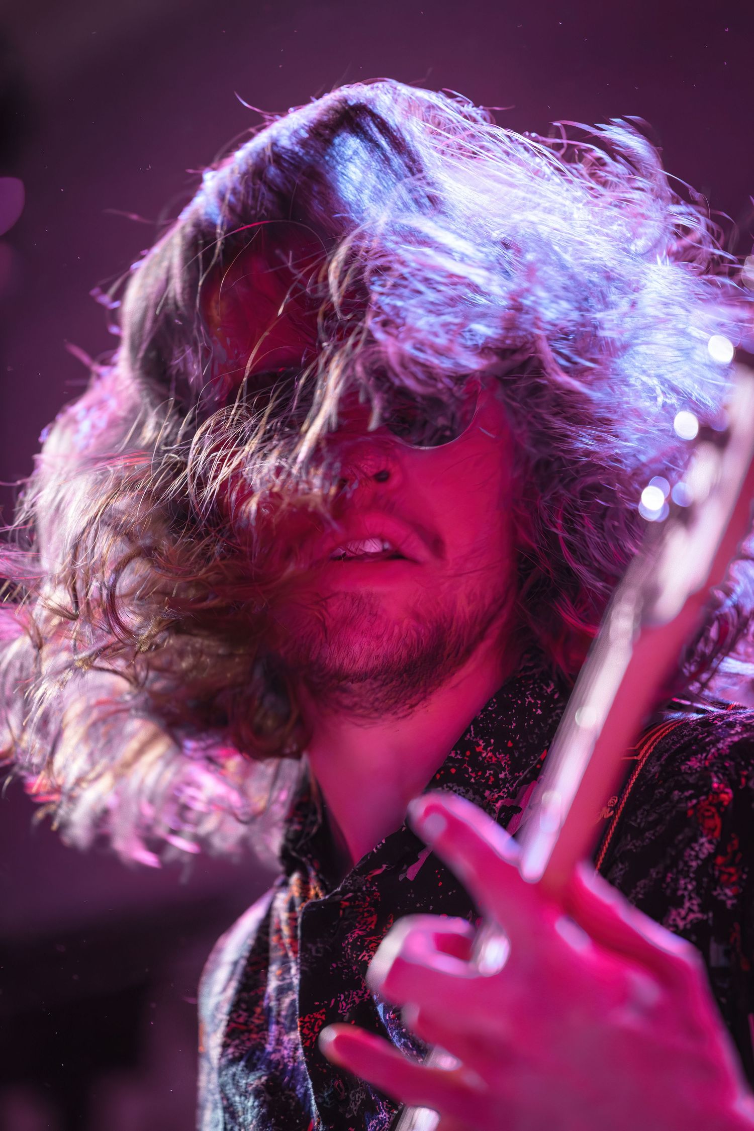 Dynamic concert photo sequence showing energetic hair flips in dramatic purple and red stage lighting.