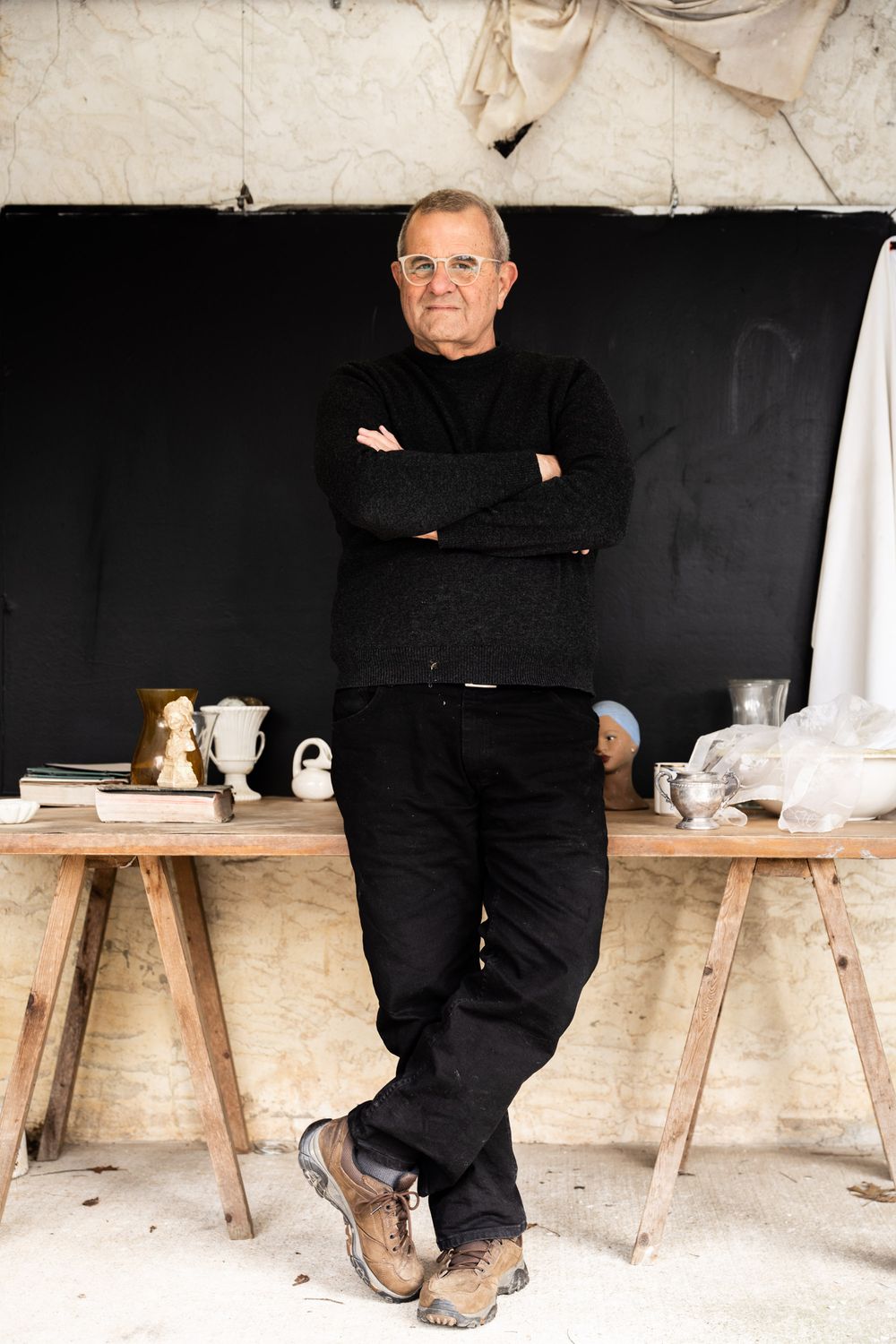 Full-body professional portrait of a woman in black standing in a bright artisan workshop; brand retainer photography for Italian business o