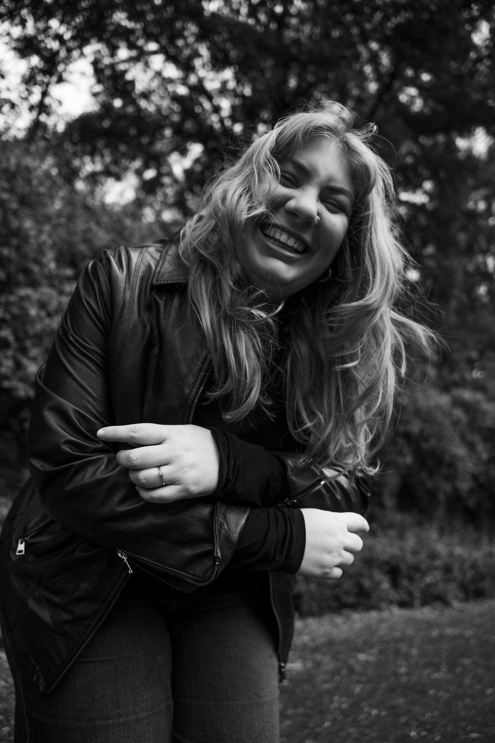 Black and white outdoor portrait of a woman laughing in a Tuscan garden; candid lifestyle photography for travelers in Florence.
