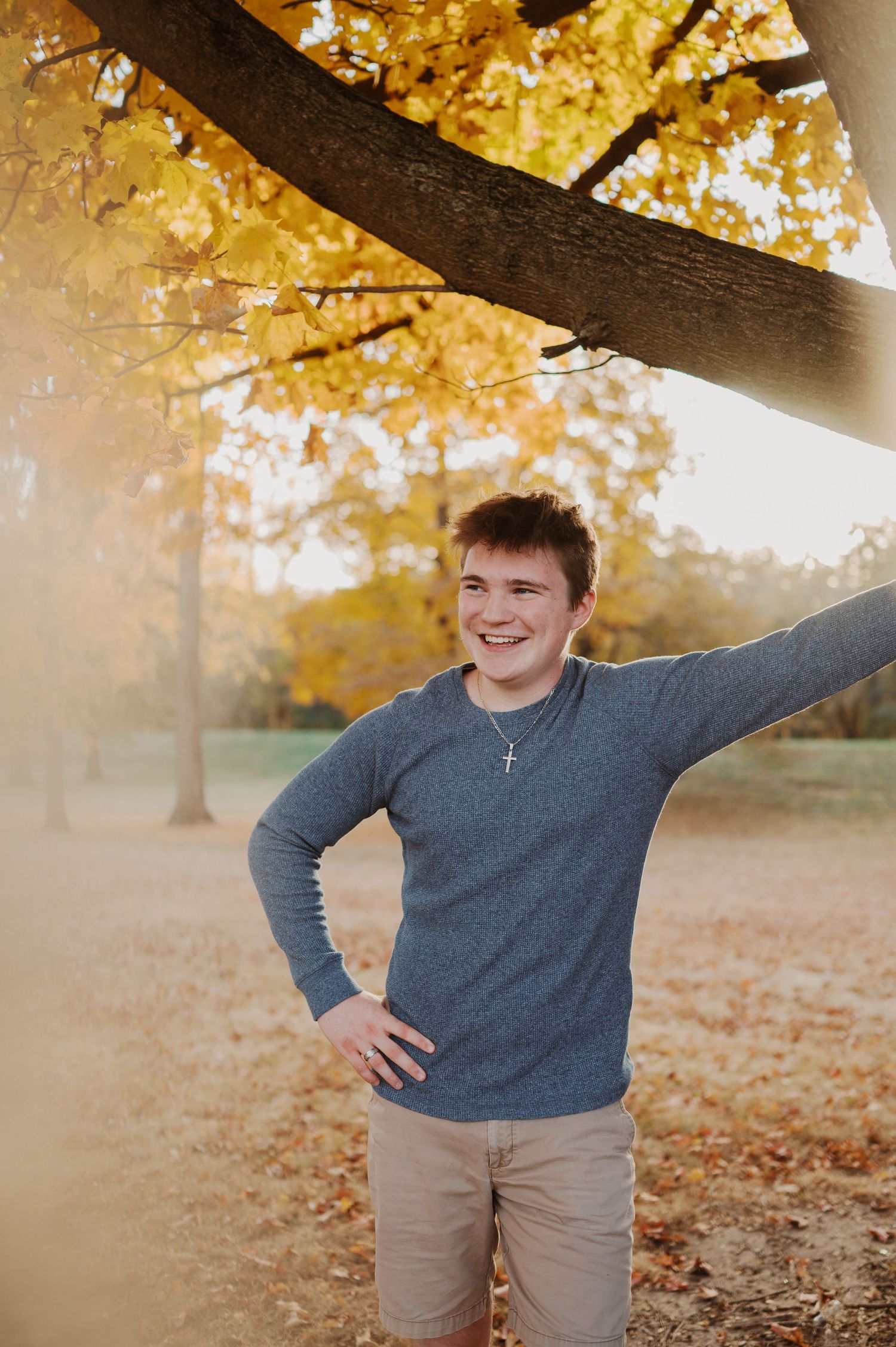 Fall foliage frames playful poses in a sunlit autumn photo session.