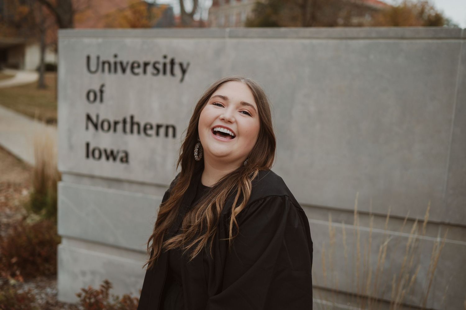 Joyful expressions captured in front of University of Iowa signage on an overcast day.