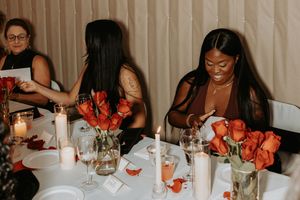 People gathered around a dinner table with candles and drinks for an evening celebration.