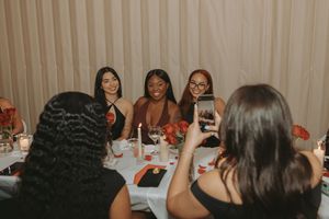 Friends gathered around a dining table for a celebratory meal with festive decorations.