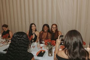 Guests seated at decorated banquet tables during a formal indoor celebration.