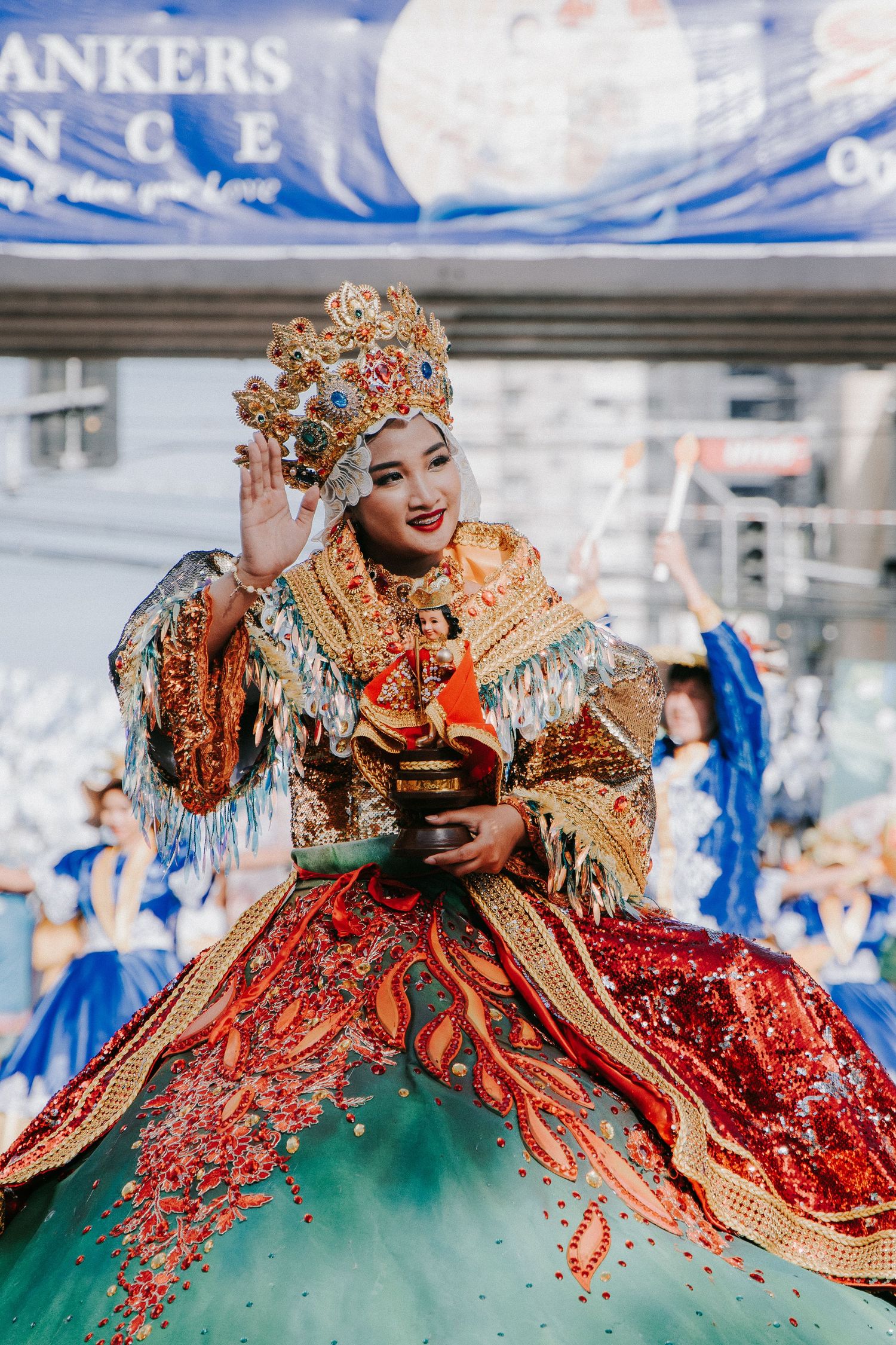 Dancers in ornate red and green costumes performing at a cultural festival.