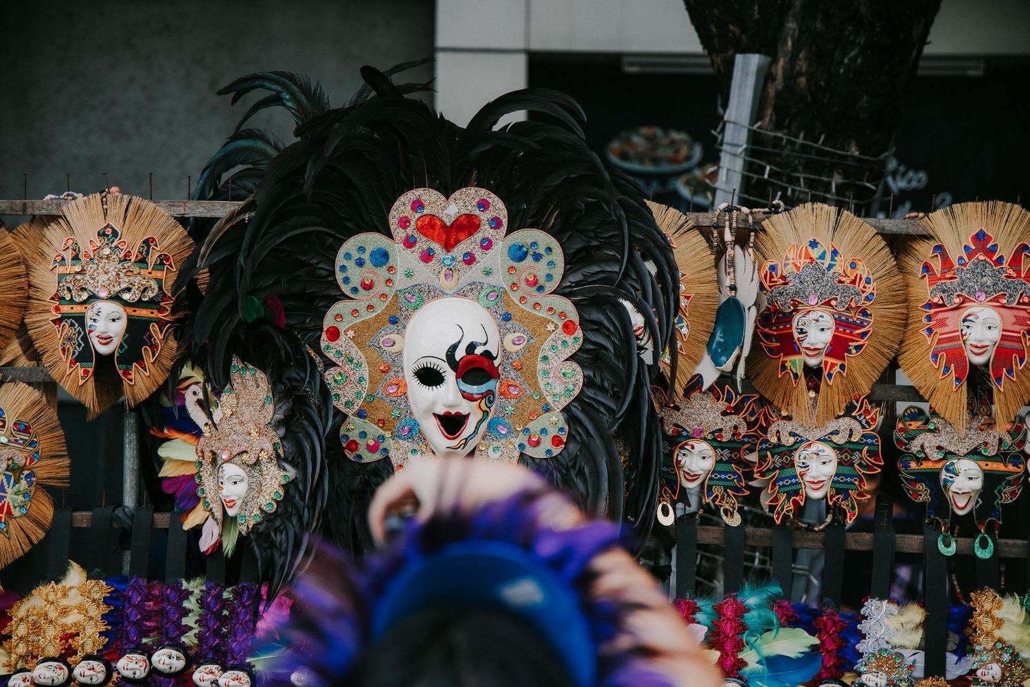 Display of ornate festival masks with intricate designs and decorations.