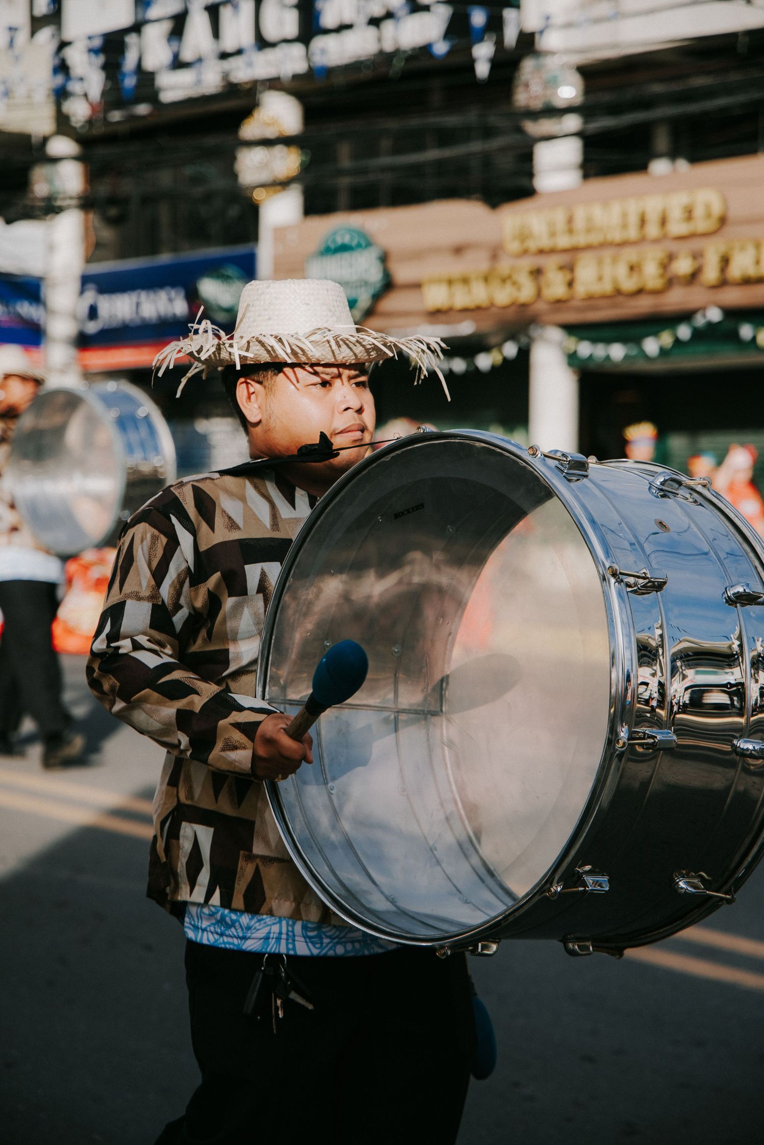 Row of large drums being played during a street performance.