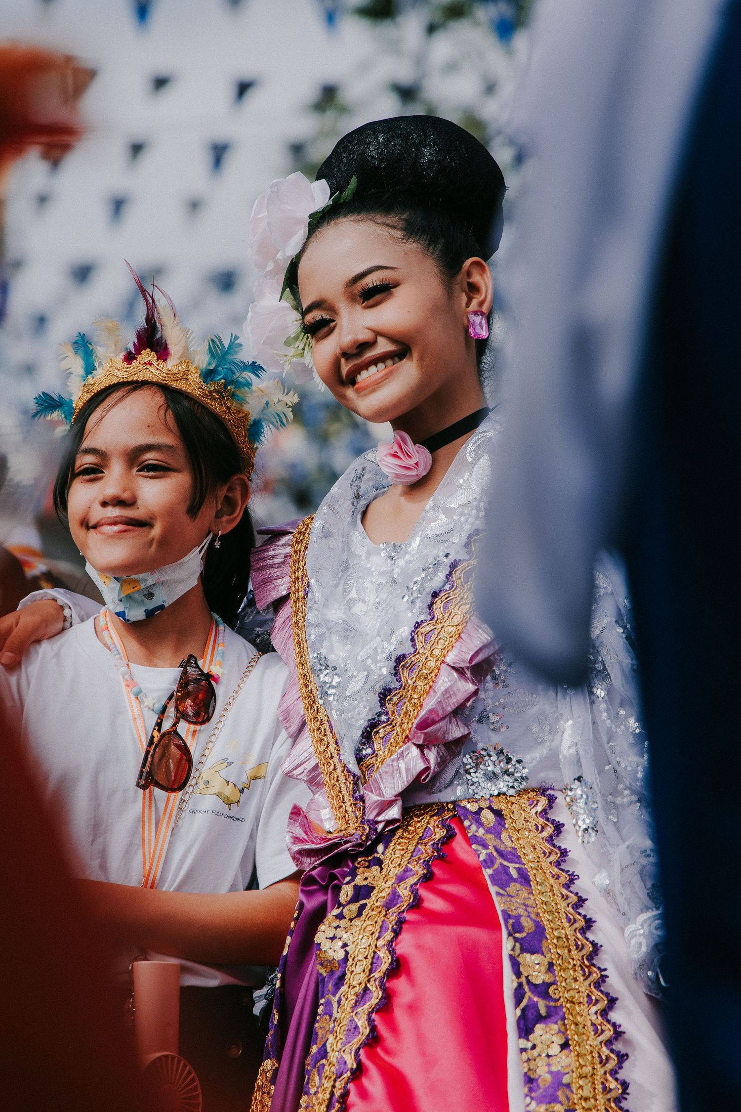 Festival participants wearing colorful traditional Filipino costumes and crowns at a cultural celebration.