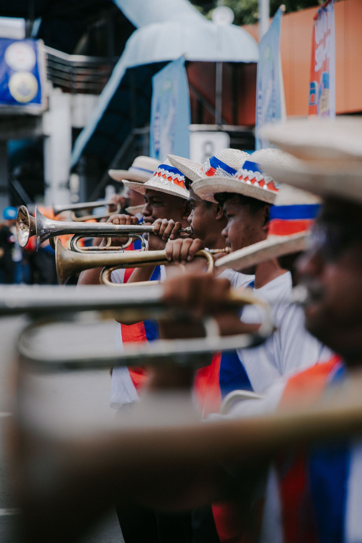 Musicians in white uniforms play traditional instruments during festival performance.