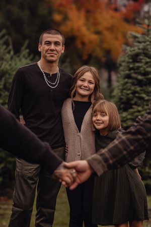 A couple shares joyful moments together during an autumn photoshoot with fall foliage in the background.