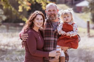 Family members embracing and smiling together during an outdoor autumn photo session.