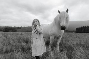 A series of black and white photographs showing horses grazing in misty fields with dramatic cloudy skies.