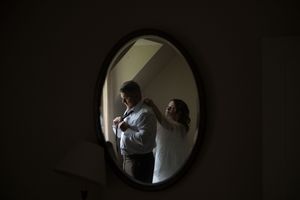 A series of seven dark circular frames showing silhouettes of a person reflected in a mirror.