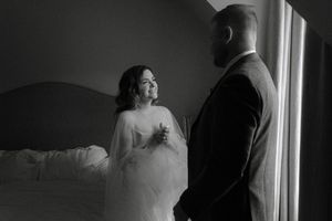 A romantic black and white wedding photo series showing tender moments between a bride and groom near a window.