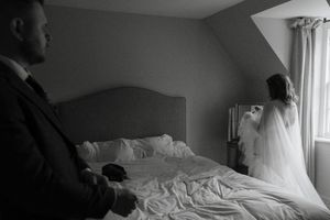 A series of black and white photographs showing someone making a bed with crisp white linens and pillows.
