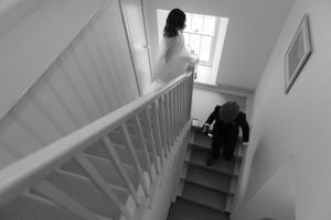 A sequence of surveillance camera stills showing someone walking up a staircase in black and white footage.