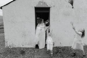 Five vintage black and white photographs arranged in a row showing people in white clothing against white walls.