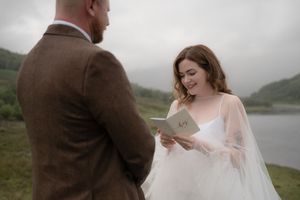 A couple shares an intimate moment during their wedding photoshoot in a misty mountain landscape.