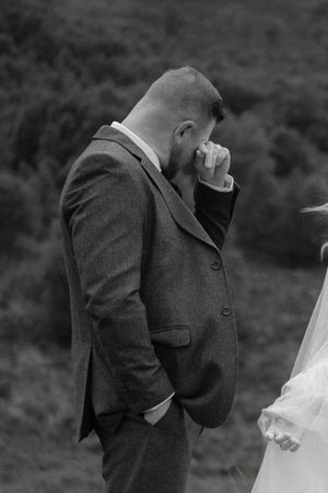 A black and white photo series shows an emotional first look moment between a bride and groom outdoors.