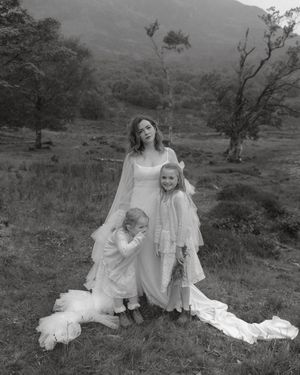 Black and white photos show people in white dresses sitting together on a grassy hillside in nature.