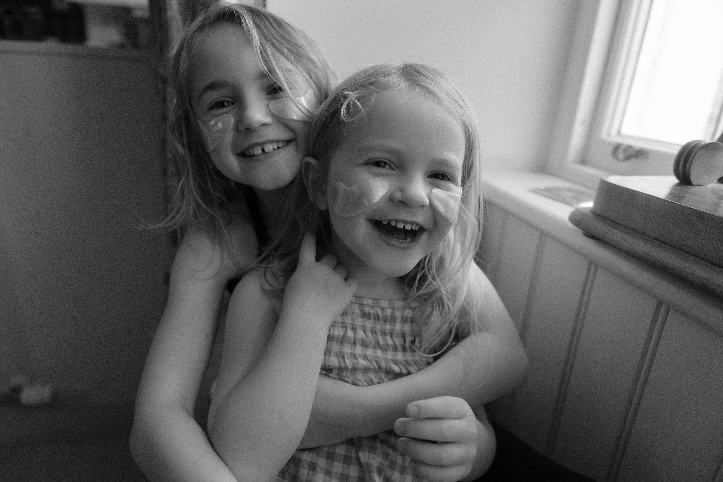 A series of black and white candid photos showing joyful expressions and laughter in a natural home setting.