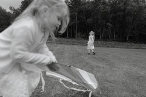 Multiple monochrome images of people in white dresses running and playing in an outdoor field.