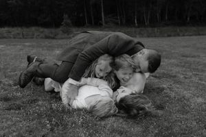 A sequence of black and white photos showing people lying on grass in a playful manner.
