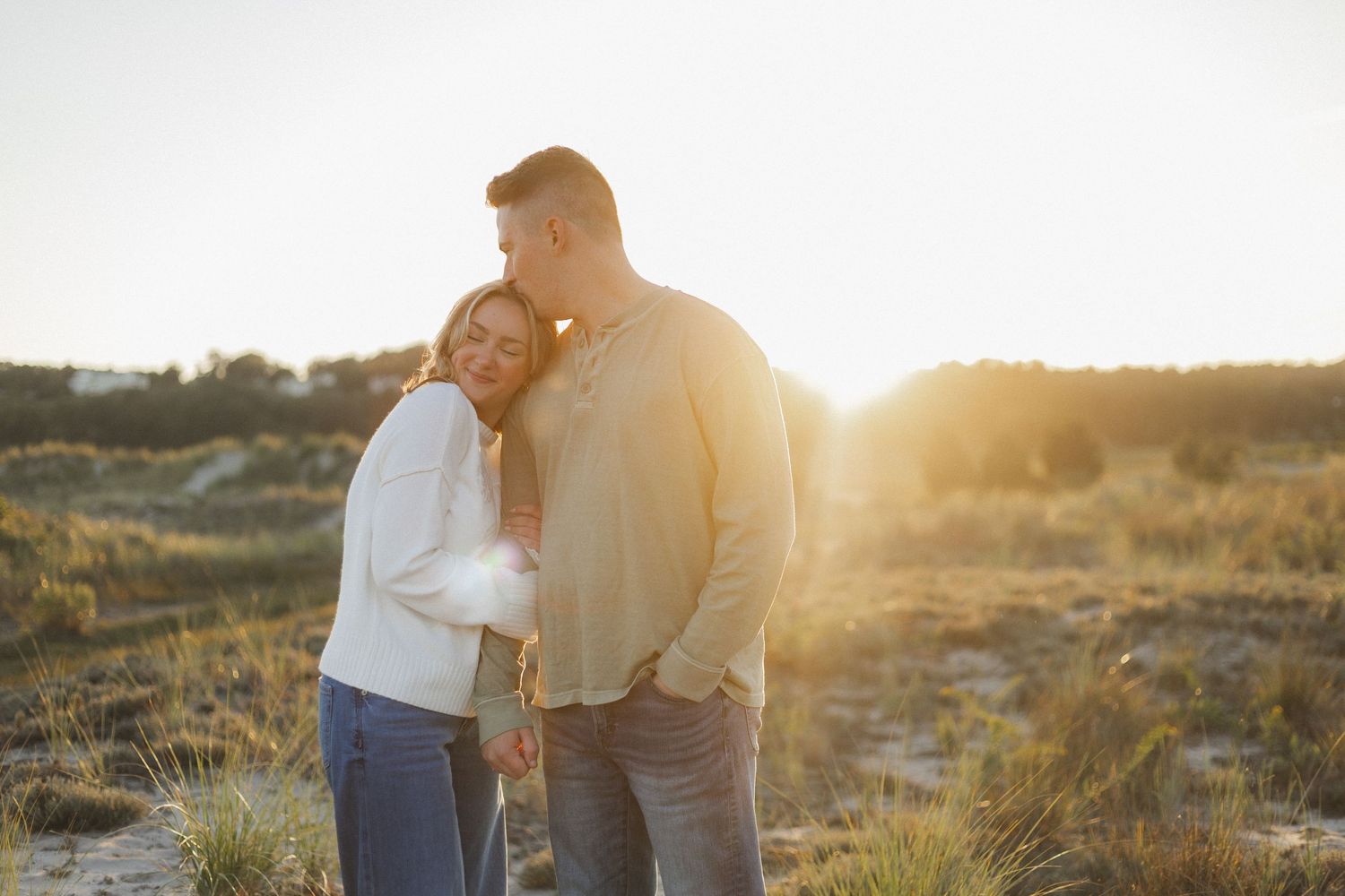 A romantic engagement photo session in a golden marsh field during sunset.