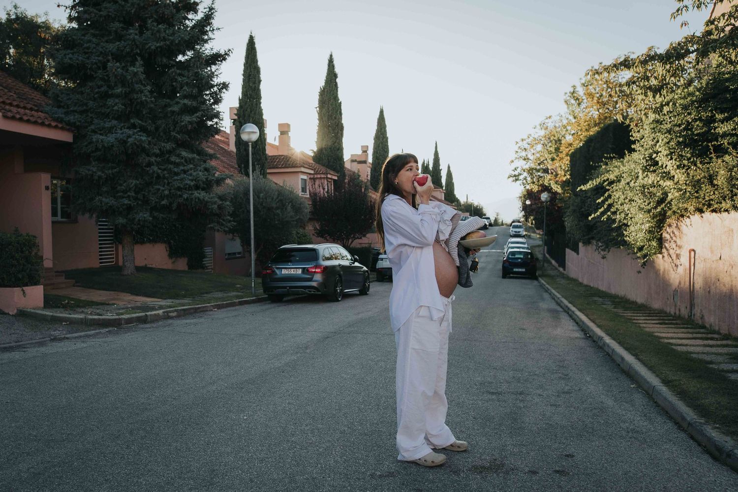 A sequence of color photos capturing someone in white attire walking along a tree-lined suburban street.