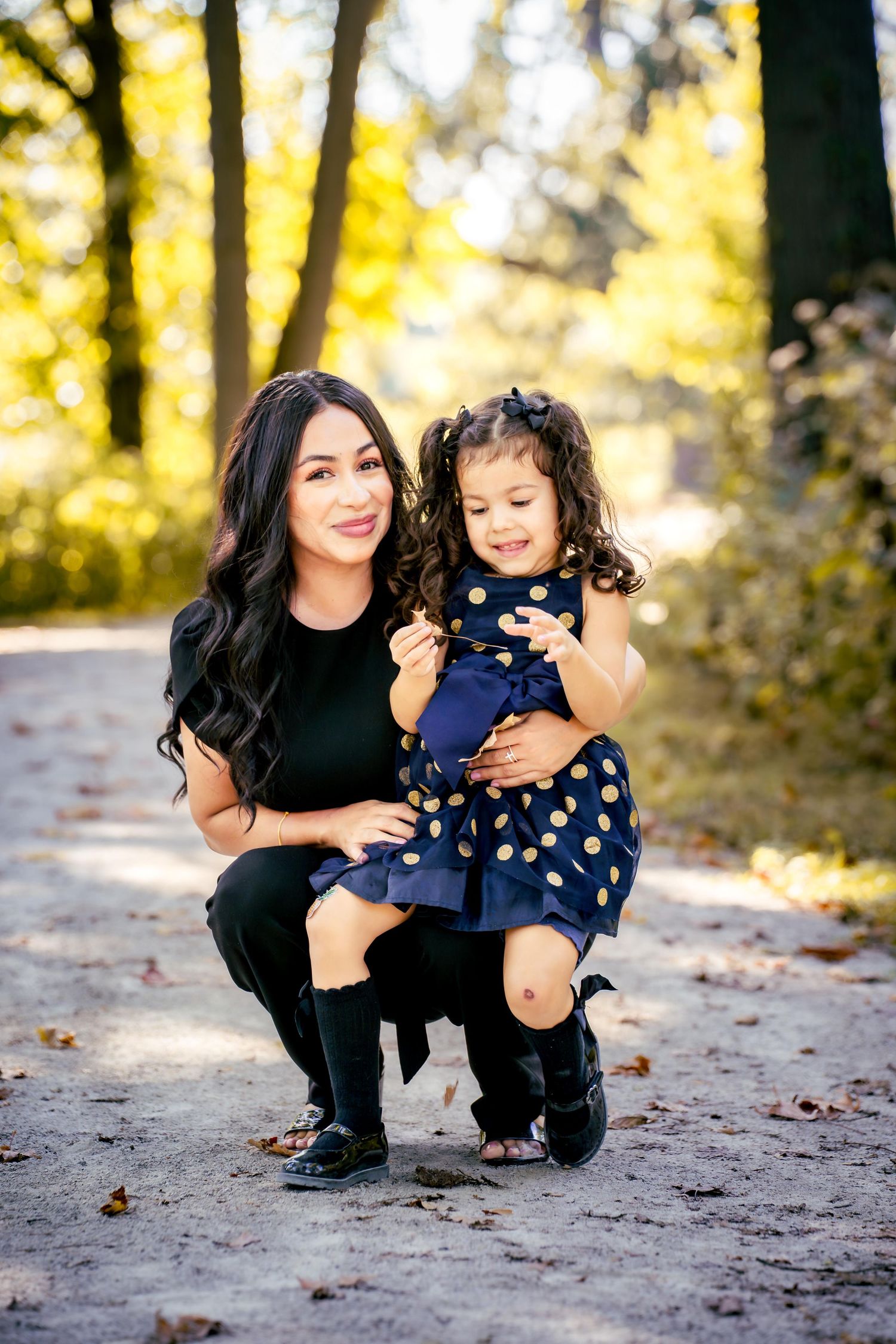 A heartwarming outdoor portrait in an autumn setting with fall foliage in the background.