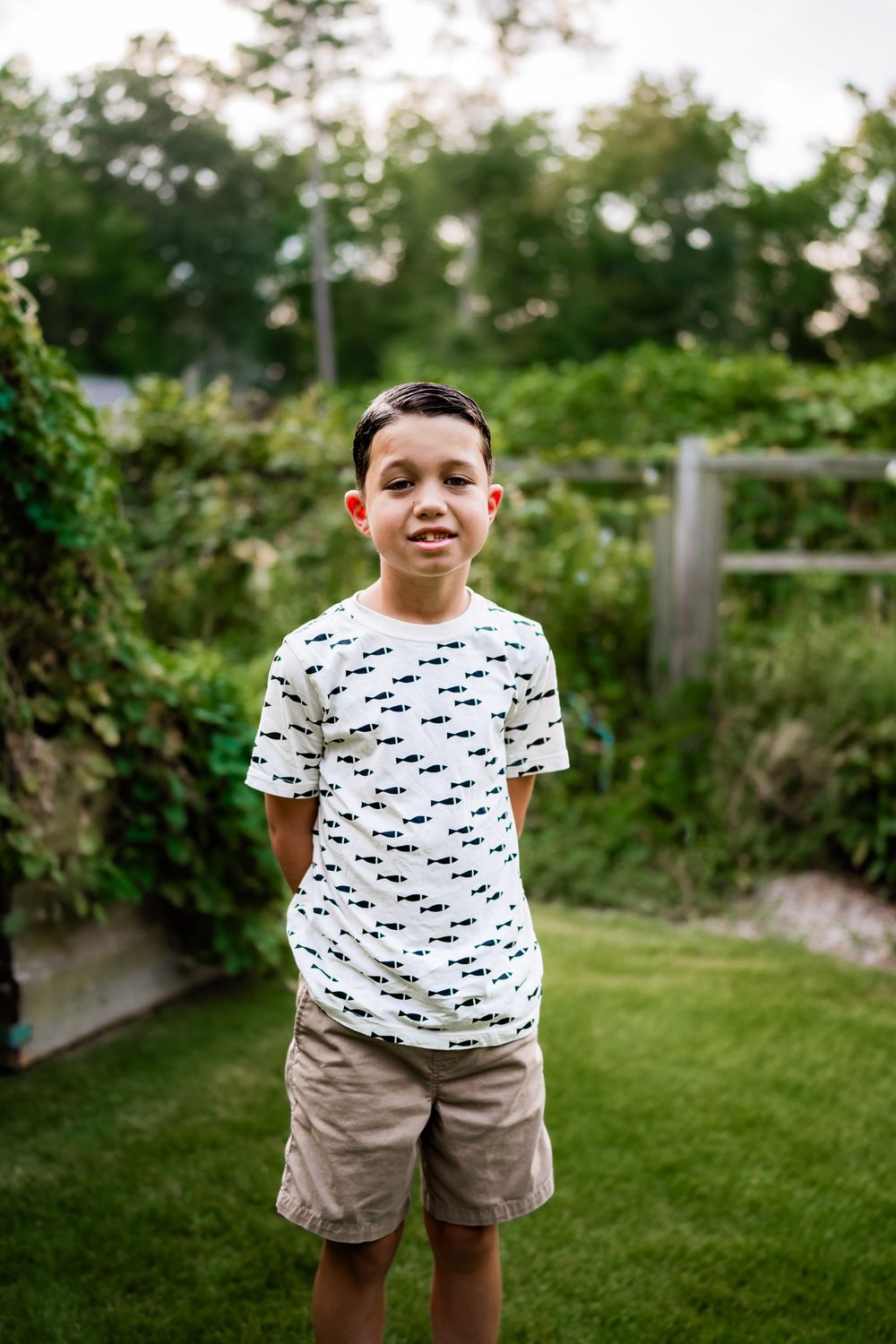 A series of outdoor portraits showing someone wearing a patterned t-shirt and khaki shorts in a backyard garden setting.