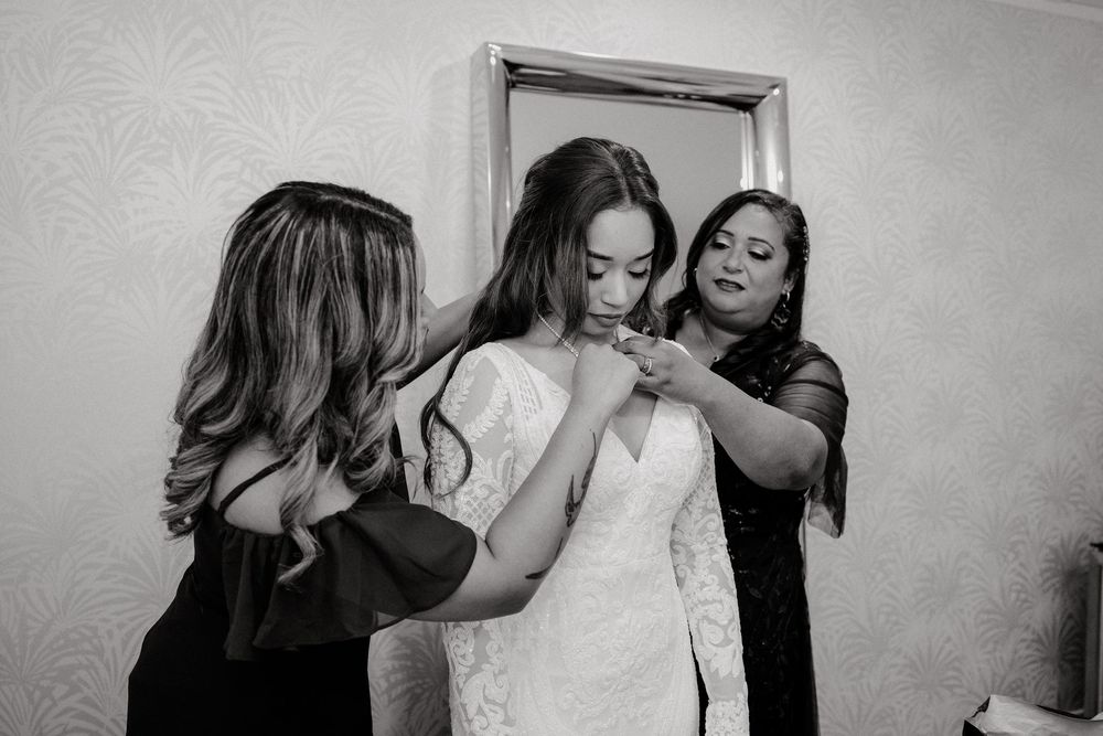 Black and white photo capturing candid moments during wedding preparations.