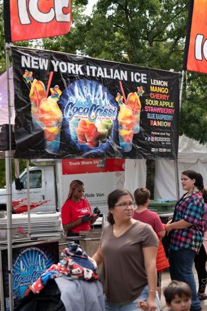 Ice cream vendor banners displaying various flavors at an outdoor festival.