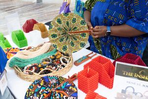 Colorful African print fabrics and textiles displayed at outdoor market stall.