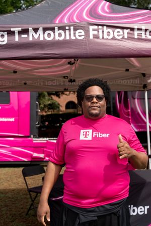 T-Mobile Fiber booth with magenta branding and tent display at outdoor event.