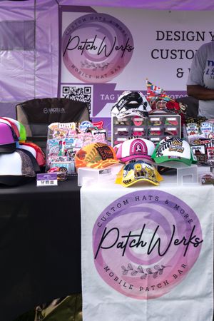 Display of custom patch merchandise with purple branding and signage at a vendor booth.