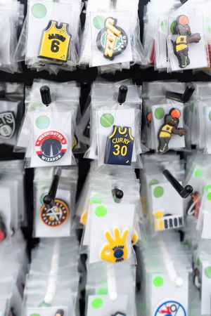 Collection of sports-themed pins and badges displayed in clear plastic sleeves.