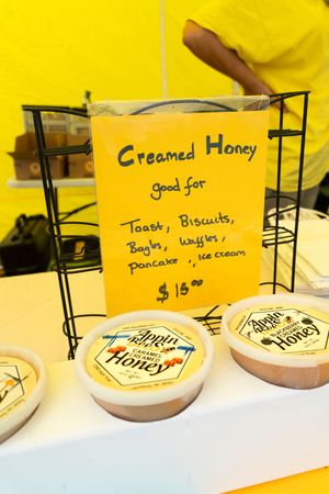 Menu board displays prices for honey and breakfast items on white plates against a yellow background.