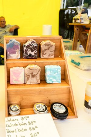 Wooden display shelf showcasing handmade soaps and beauty products with natural-colored packaging.