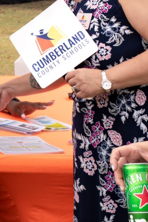 Close-up of floral patterned fabric with Cumberland school materials on an orange table surface.