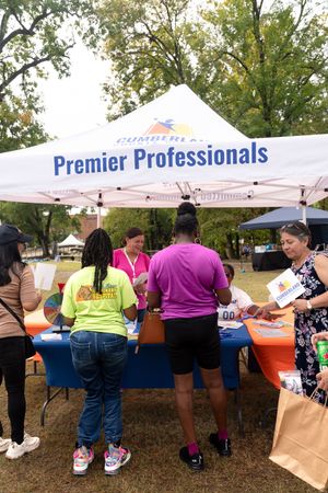People lined up at outdoor festival booths under tents and banners.