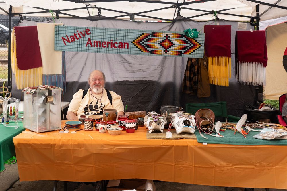 A Native American themed display table with banners and decorative items set up at an indoor event.