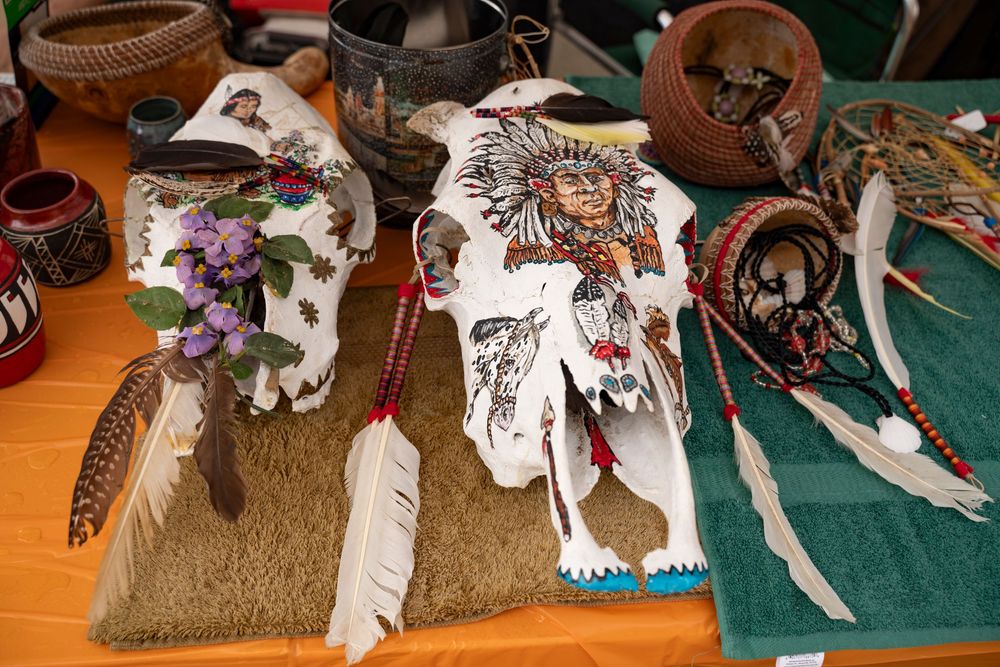 Handmade decorative ornaments featuring rustic burlap, pinecones, and white ribbons arranged in a festive display.